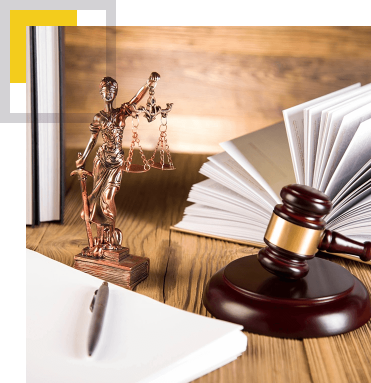 A wooden table with a statue of justice and books.