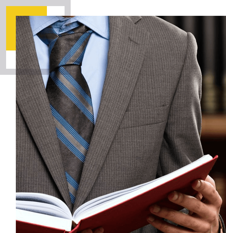 A man in suit and tie holding an open book.